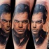Portrait style colored arm tattoo of creepy Dexter face