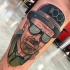 Portrait style colored leg tattoo of cool movie hero