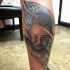 Portrait style colored leg tattoo of little boy face