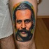 Portrait style colored thigh tattoo of of man with mustache
