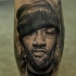 Portrait style realistic looking tattoo of thigh man face