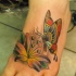 Tatuaje en el pie,
mariposa con lirio, diseño abigarrado