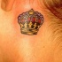 Tatuaje de corona lujosa detrás de la oreja