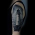 Tatuaje en el brazo, faro grande muy realista en la oscuridad