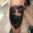 Realism style colored leg tattoo of woman in mask