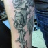 Realism style colored revolver tattoo on forearm with rose vine