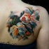 Realism style colored scapular tattoo of small beautiful fishes