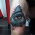 Realism style colored thigh tattoo of mystic eye and leaves