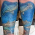 Realism style large colored forearm tattoo of underwater sharks