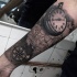 Tatuaje en el antebrazo, mapa del mundo con reloj y compás, tema náutico