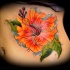 realistico fiore ibisco arancione tatuaggio sulle costole