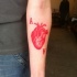 Tatuaggio  rosso sul braccio cuore & 