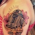 Tatuaje en el hombro, R2D2 magnífico 3D con flores exóticas y inscripción