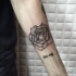 Rose flower tattoo on forearm in dotted work with black ink lettering