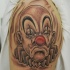 Tatuaje  de payaso triste en el brazo