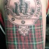 stoffa scozzese con cerchio e castello tatuaggio su spalla