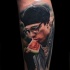 Tatuaje en la pierna, retrato realista de Sergei Bodrov que come una sandía