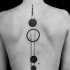 Tatuaje en la espalda,
planetas de tamaños diferentes, tinta negra