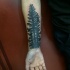 Simple black ink forearm tattoo of dark forest