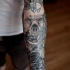 Tatuaje en el brazo, cráneo con alas y rosa, diseño precioso