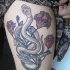Tatuaje en el brazo,
serpiente simple con flores de color púrpura