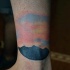 Tatuaje en el tobillo,  montañas pequeñas con salida del sol