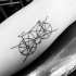 Tatuaje en el brazo,
bicicleta simple tachada, tinta negra