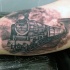 Tatuaje en el brazo, tren viejo con  ferrocarril
