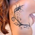 Tatuaje en el costado, tallo con hojas y rizos, tinta negra