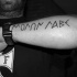 Tatuaje en el antebrazo, inscripción misteriosa de tinta negra