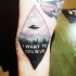 Tatuaje en el brazo,  nave extraterrestre diminuto sobre el campo y inscripción