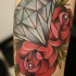 Tatuaje en el brazo, diamante precioso con dos rosas rojas