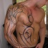 Simple unfinished black ink sleeve and chest tattoo of various tribal ornaments