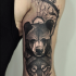 Sketch style black ink arm tattoo of bear and wolf head with tree