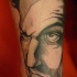 Sketch style black ink arm tattoo of big man face