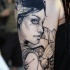 Sketch style black ink shoulder tattoo of woman with needles