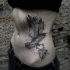 Sketch style black ink side tattoo of crow with human heart