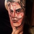 Sketch style colored shoulder tattoo of mans face