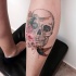 Tatuaje en la pierna, cráneo y aves