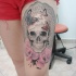 Tatuaggio colorato sulla gamba il teschio femminile con le rose rosa by Cassio Magne