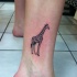 Tatuaje de jirafa pequeña simple en la pierna