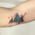 Small abstract style colored mountains tattoo on elbow