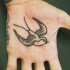 Tatuaggio sulla mano la rondine nera