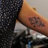 Small black ink arm tattoo of interesting ornament