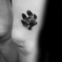 Small black ink thigh tattoo of animal paw print