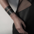 Small black ink wrist tattoo of simple ornament