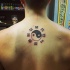 Kleines schwarzes Yin-Yang Symbol Tattoo am Rücken