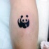Small blackwork style leg tattoo of small panda bear