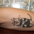 Small cartoon style arm tattoo of funny cat