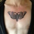 Small cartoon style chest tattoo of little butterfly